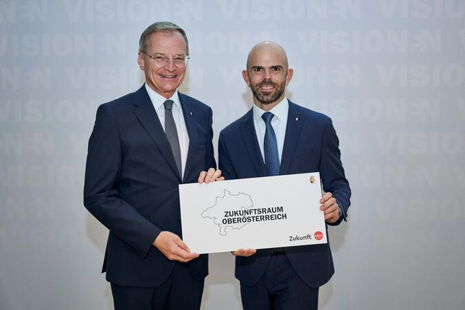 LH Thomas Stelzer zusammen mit Oö. Zukunftsakademie Leiter Markus Scharner vor einer Pressewand.