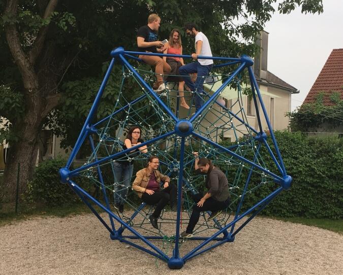 Ausgangsfoto Titelblatt Co-Design Zukunft_Ausschnitt - 6 junge Personen sitzen verteilt in einem Spielraumwunder-Gerät