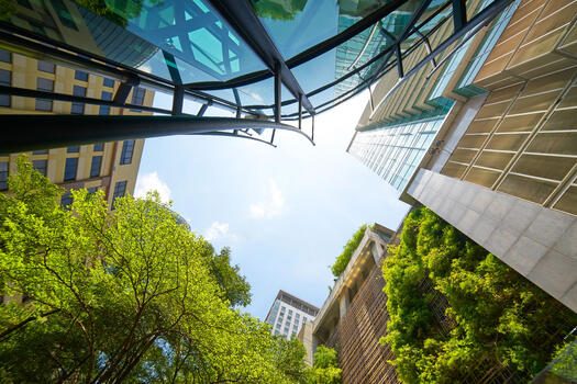 Moderne Gebäude Glasfassaden und Bäumen von unten aufgenommen