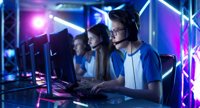 Team von Teenager-Spielern spielen im Multiplayer-PC-Videospiel auf einem eSport-Turnier. Captain gibt Befehle ins Mikrofon und versucht, das Spiel strategisch zu gewinnen.